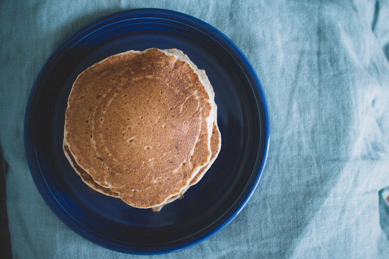 hero-img-01 Aerial view of homemade pancakes on a blue plate, ready for breakfast.